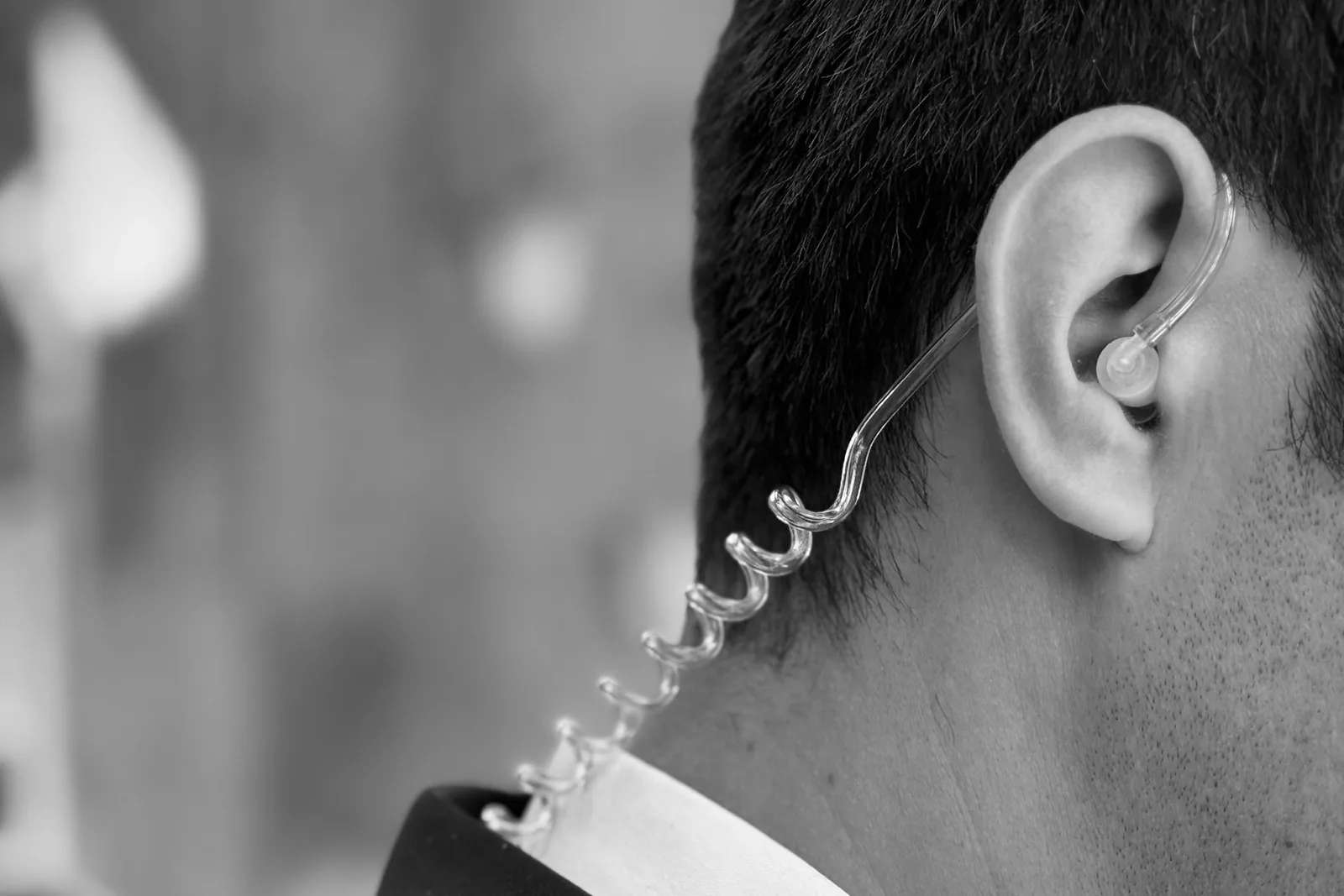 Close-up of a security earpiece worn by an executive protection agent, symbolizing discretion and confidentiality
